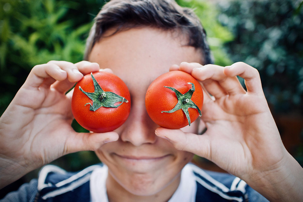 Junge mit Tomaten