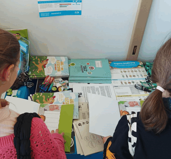 Kinder schauen sich Infomaterial von PETA-Kids an
